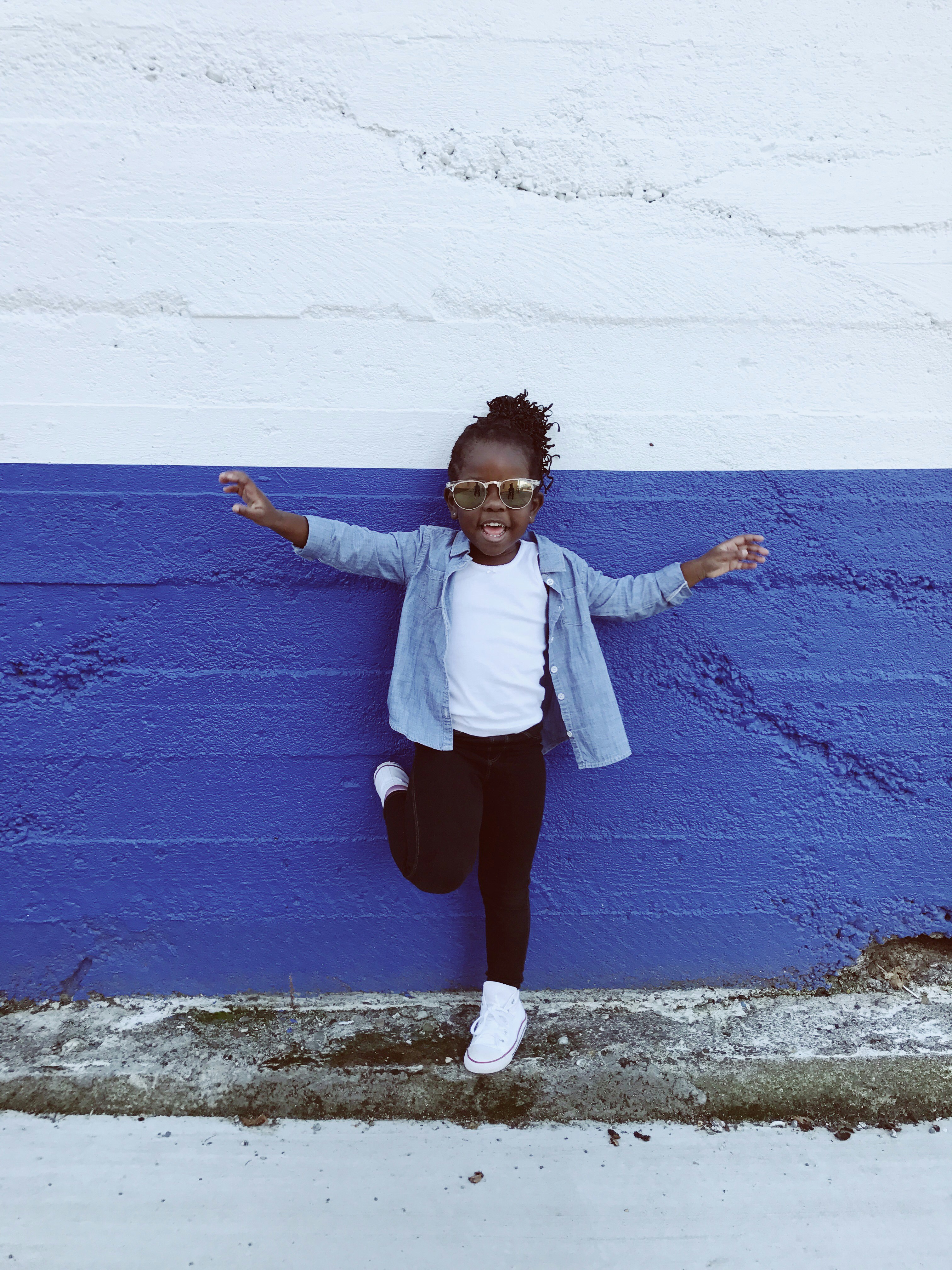 girl leaning on wall during daytime